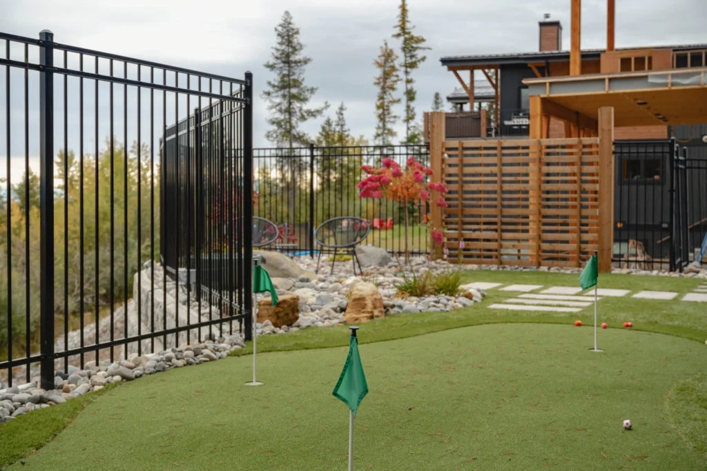 Low-maintenance garden enclosed by black ornamental fencing