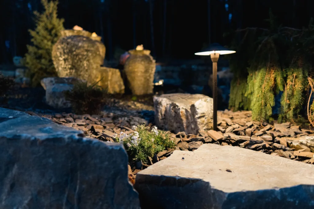 Landscape lighting illuminating the urn water feature at night