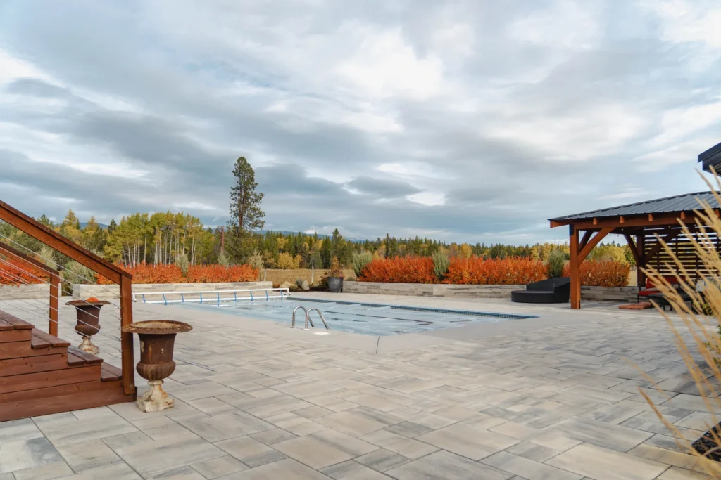 Wide view across the pool deck toward the covered pergola