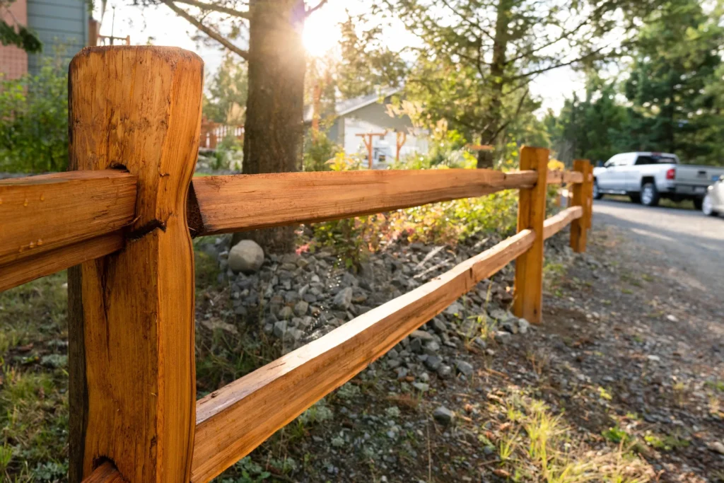 Rough-cut cedar post-and-rail fence in warm evening light