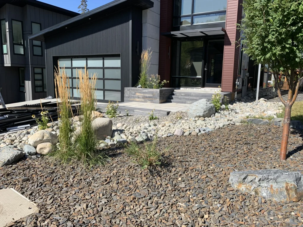 Modern home entrance softened with grasses and round rock