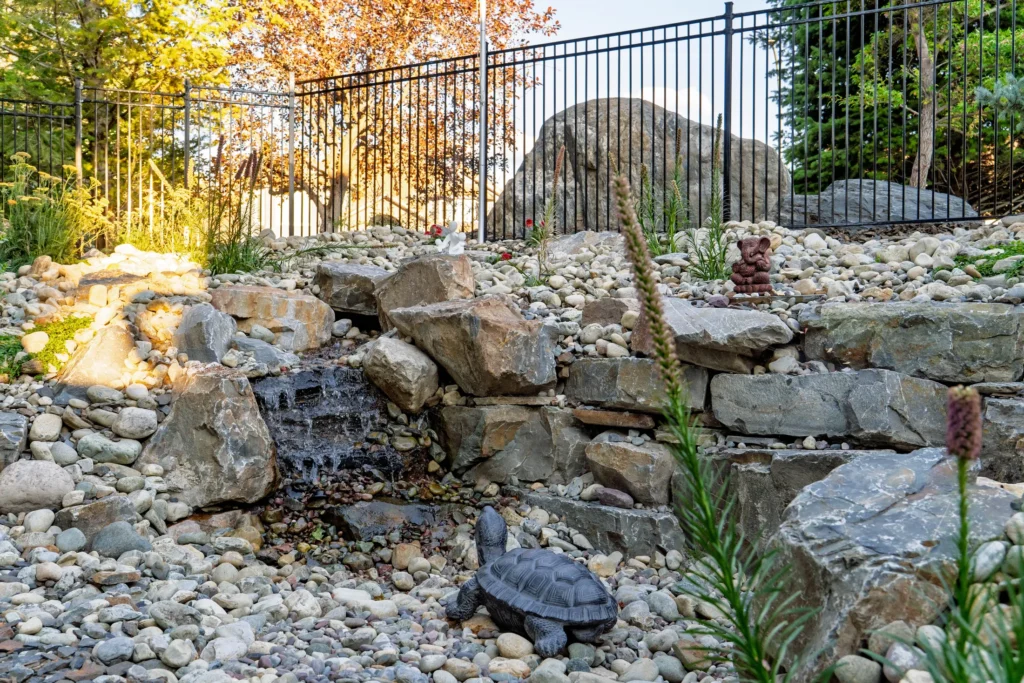 Stacked stone stream with bird bath and pollinator plantings