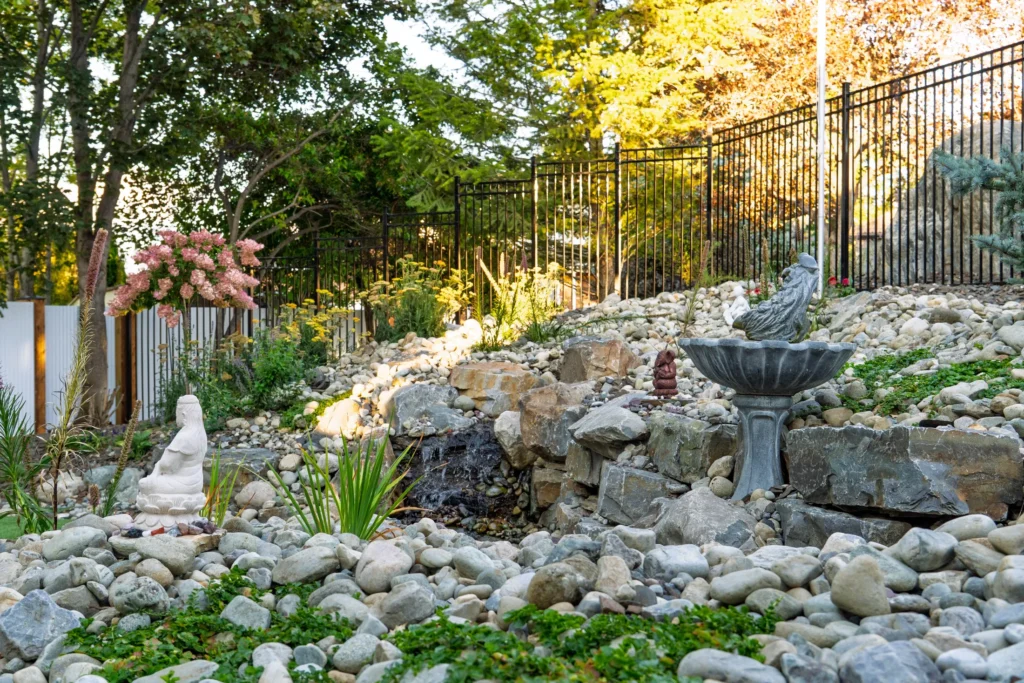 Homeowner bird bath incorporated into the stream among colourful plantings