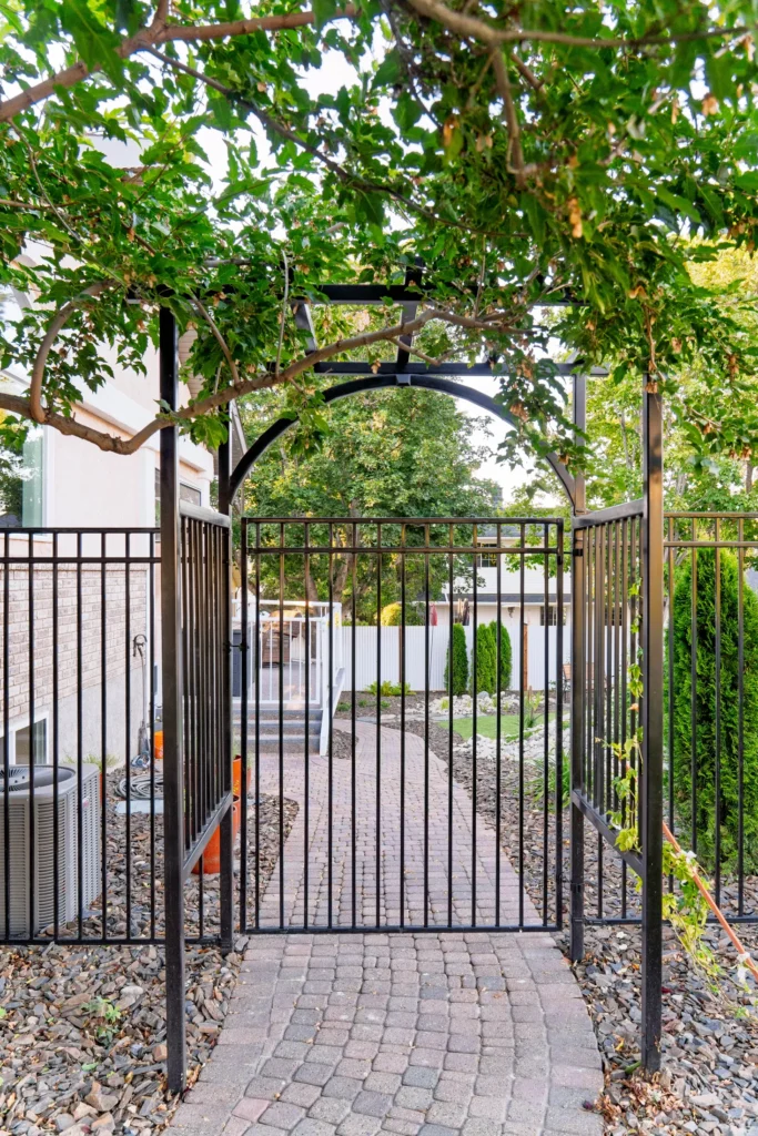 Custom arched arbor gate opening onto the backyard walkway